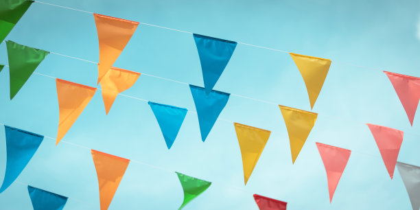 五彩缤纷的彩旗背景悬挂在蓝天上，为欢乐节日派对活动、夏日假日农场盛宴庆典、嘉年华节日活动、公园或街头节日设计装饰图片下载