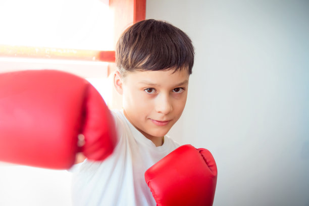 一个学龄男孩在隔离期间在家打拳击。运动不是障碍。意志力是由训练培养出来的。图片下载