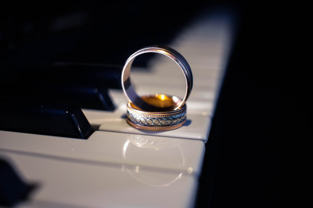 两个结婚戒指放在钢琴上图片下载