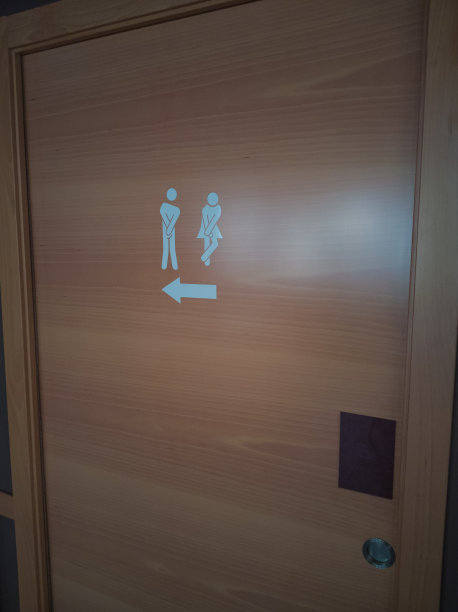 一个公共厕所的门上画着一个男人和一个女人在做滑稽的姿势图片下载