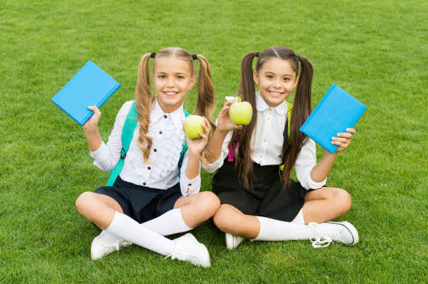 水果的知识。快乐的孩子们在绿草地上拿着苹果。维生素的水果。学校打破。零食和水果。有机水果。健康食品。营养和健康教育图片下载