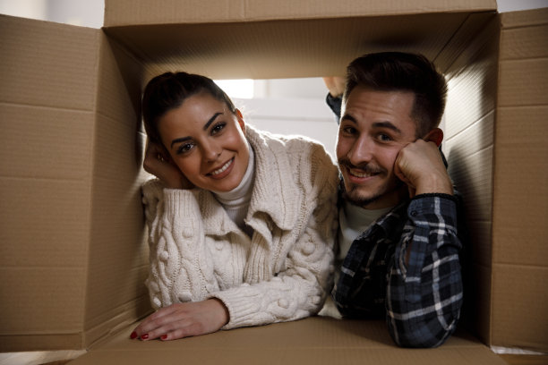 一对夫妇躺在盒子里，对着镜头微笑图片下载