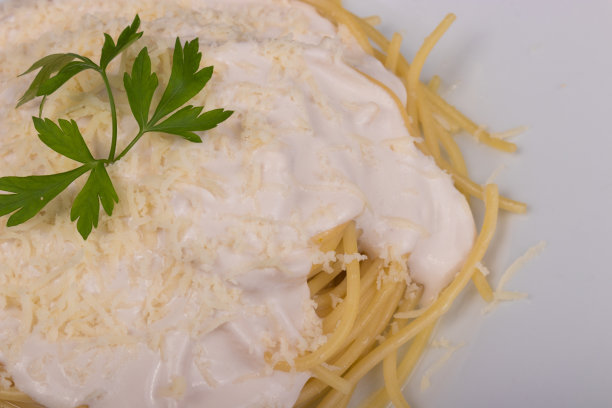 意大利面配白酱，磨碎的奶酪和欧芹叶。文件夹的特写照片图片下载