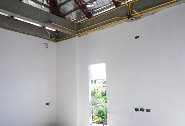 施工现场用轻质水泥砖和白色过梁灰泥加固寡妇房屋框架。黄色电灯系统管图片下载