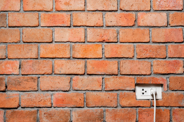 抽象的橙色砖墙，电源插头纹理背景图片下载