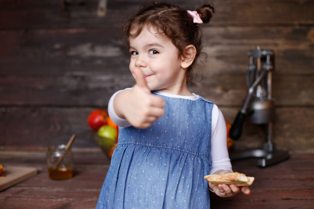一个漂亮的白人小女孩正在吃热烤三明治。库存图片图片下载
