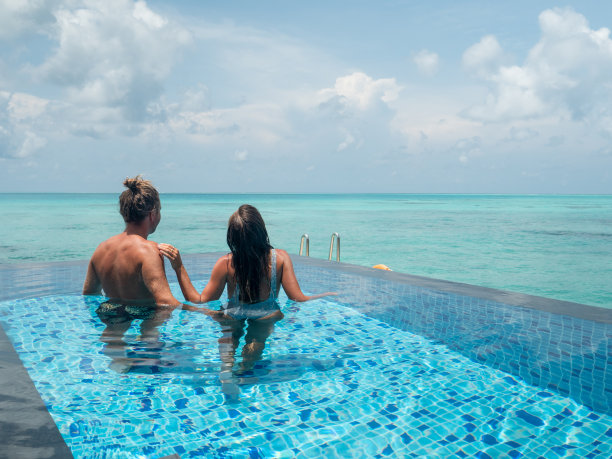 情侣在豪华度假胜地游泳池浪漫的暑假图片下载
