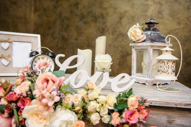 婚礼装饰照片:一个古老的木质桌子，插花，相框，蜡烛，灯，上面刻有“爱”的白色字样图片下载