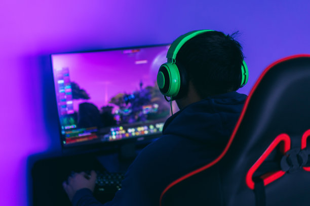 游戏玩家喜欢玩电脑游戏。一个现代的爱好，玩电脑游戏。侧视图图片下载