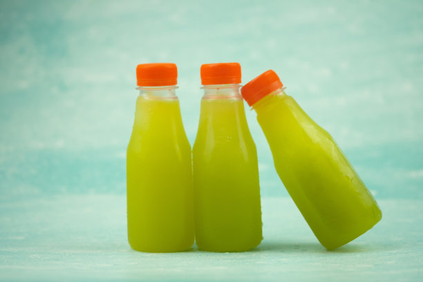 新鲜甘蔗汁在塑料瓶。三个瓶子图片下载