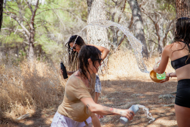 圣马丁瓦尔德伊格莱西亚斯，西班牙马德里。一群妇女在喷泉旁玩水降温。图片下载