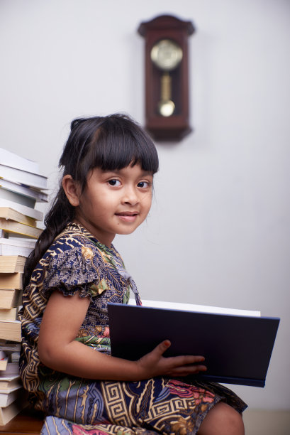 可爱的小女孩在家里读书和学习图片下载
