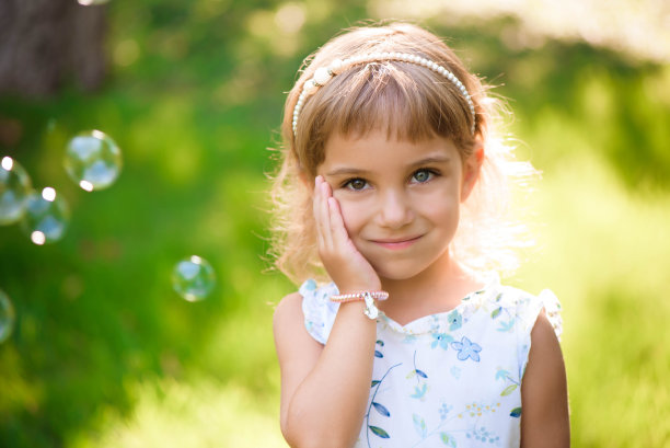 甜美，快乐，微笑的五岁小女孩躺在草地上图片下载