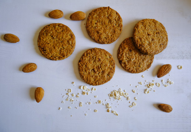 燕麦手工曲奇，白色背景上放杏仁。前视图。健康饮食。无谷蛋白甜点。无糖饼干。图片下载