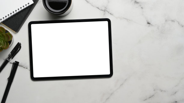 模拟图像的数字平板与空白屏幕，咖啡杯，仙人掌和笔记本上的大理石背景。图片下载