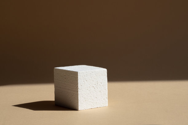 3d讲台，为包装和化妆品演示。白色泡沫立方体，在自然光线下有一个坚硬的阴影，在棕色的背景上。美容行业的概念图片下载