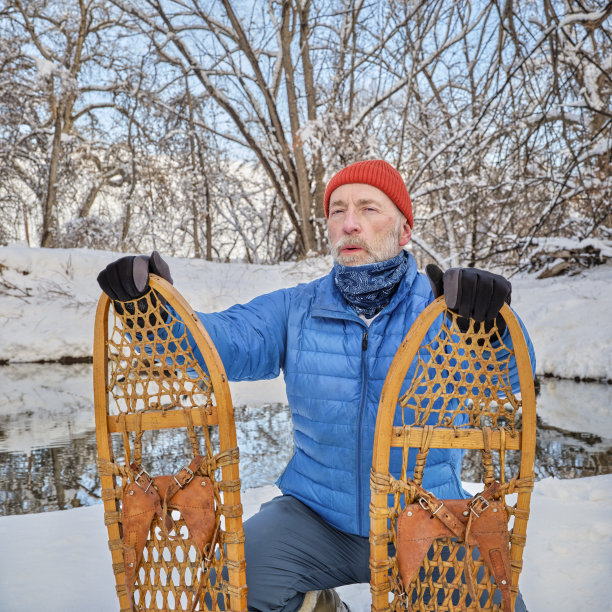 年长男性，穿着经典的木制雪地鞋(熊掌)图片下载
