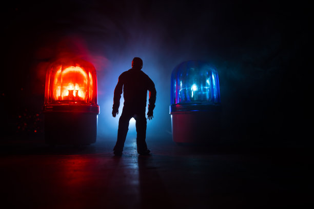 法律、法律或犯罪概念。一个人独自站在路中央，在一个雾蒙蒙的夜晚。带有手铐、正义雕像和正义锤的艺术品装饰在朦胧的背景上。图片下载