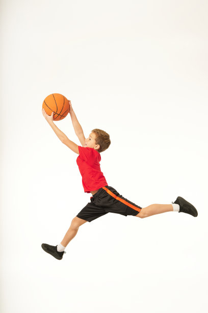 可爱的运动男孩抱着篮球和跳跃图片下载