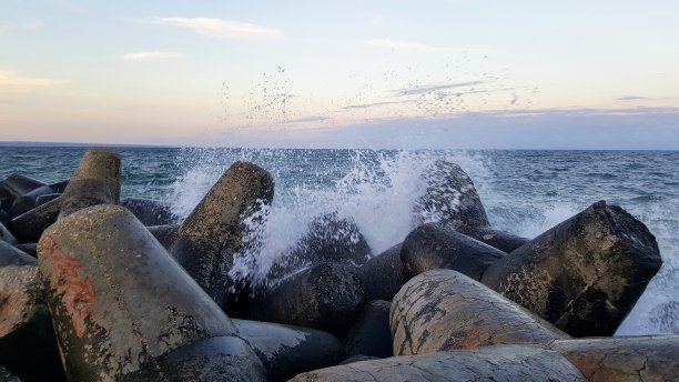 防波堤与海浪溅在日落图片下载