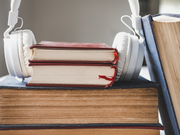 一堆旧书和一副白色耳机图片下载