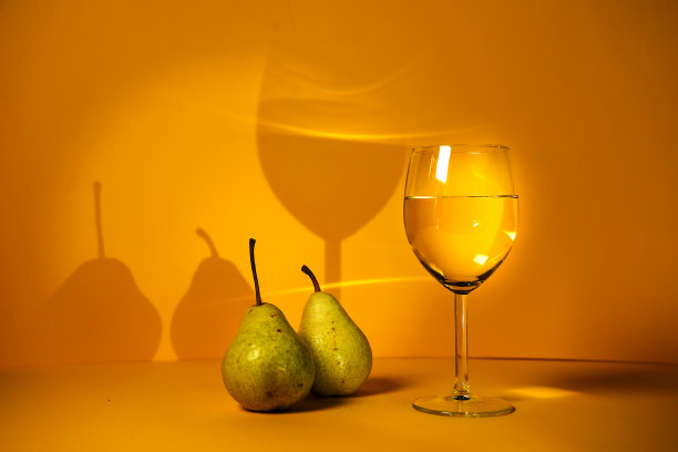 经典的静物画，梨，白葡萄酒在明亮的黄色背景上。酒庄和餐厅的广告。图片为作者的烹饪博客。saumillier。品酒。图片下载