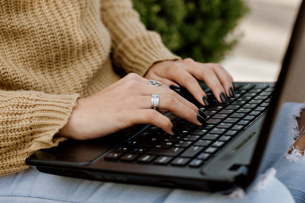 女人的手在笔记本电脑上打字。工作在户外freelanse图片下载