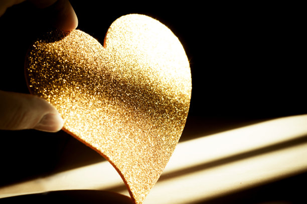 金色闪亮的心在黑色的背景上图片下载