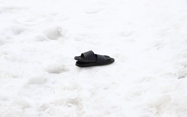 拖鞋躺在雪地上等待夏天的到来图片下载