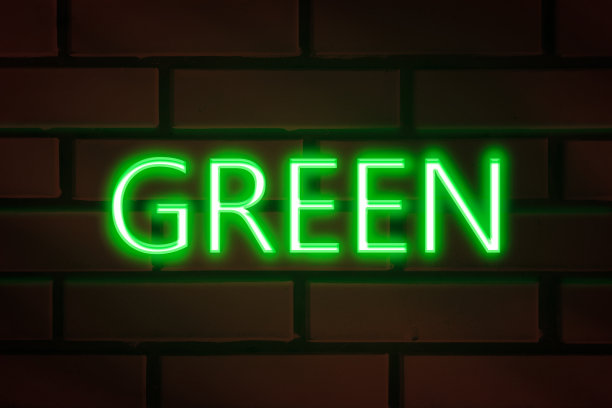 红色砖墙上的绿色霓虹灯字。图片下载