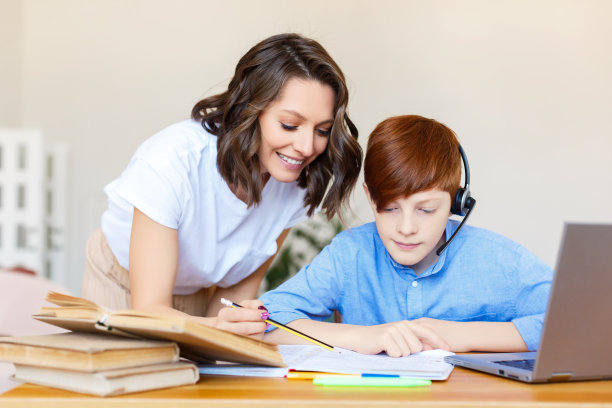 一位母亲帮助她的儿子做网上作业图片下载