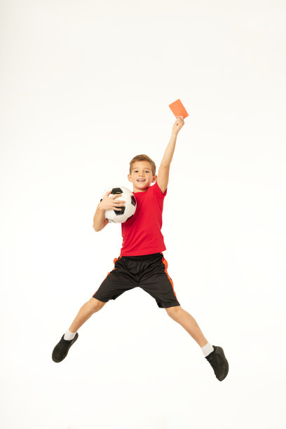 可爱的小男孩足球运动员拿着红牌跳起来图片下载