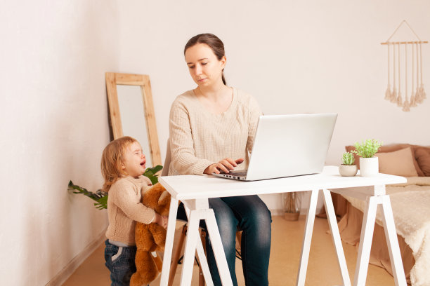 一位休产假的母亲坐在笔记本电脑前工作。孩子歇斯底里的哭闹会分散工作的注意力。一个从事自由职业的女人，疲惫，愤怒。妈妈不开心睡不着图片下载