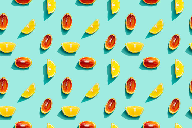 鲜艳的水果图案来自新鲜的柑橘，柠檬，红橙在蓝色的背景。夏天的食物。图片下载
