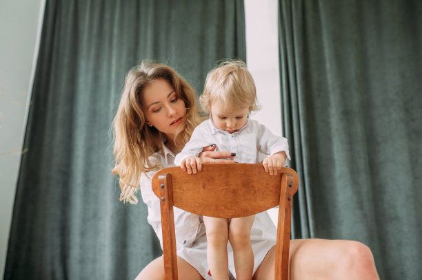 母亲坐着，抱着她的小儿子。图片下载