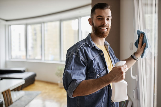 一个英俊的年轻人正在打扫他的家。家务不仅仅是女人的专利。图片下载