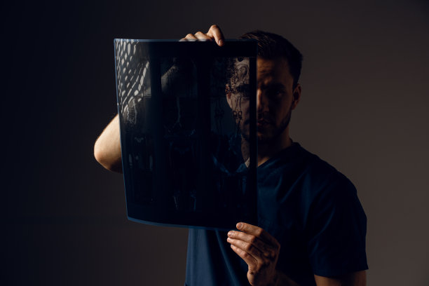 对患者进行冠状病毒covid-19 x线扫描。通过电脑断层扫描。身穿医袍的外科医生在看深色背景上的扫描图。Mri用于健康诊断图片下载