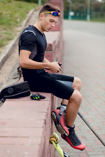 运动概念轮滑摄影。户外职业运动员的男性肖像。男人在滑旱冰。运动员在训练后坐着放松图片下载