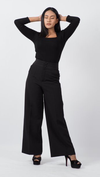 一名年轻女子穿着黑色衬衫和裤子在工作室里摆姿势，背景是白色。性感的亚洲黑发女孩与丰满的嘴唇pose相机。有吸引力的女性与大乳房。在摄影棚拍摄。图片下载