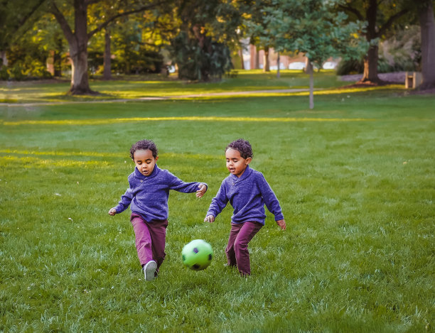 非裔美国双胞胎男孩在公园踢足球图片下载