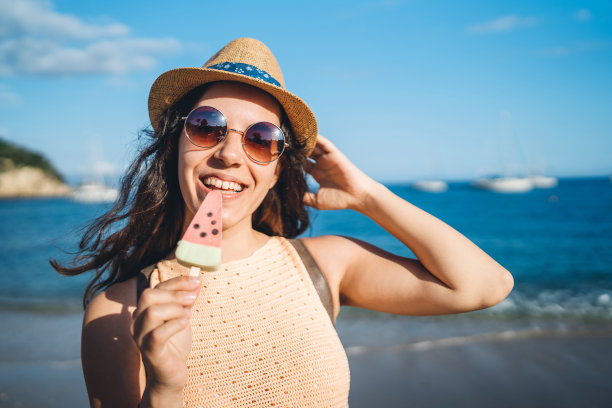 在海滩上吃冰淇淋的女人图片下载