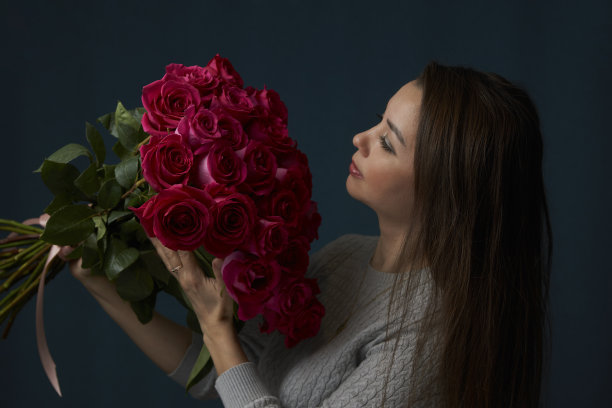 一名年轻女子手持一束玫瑰花图片下载