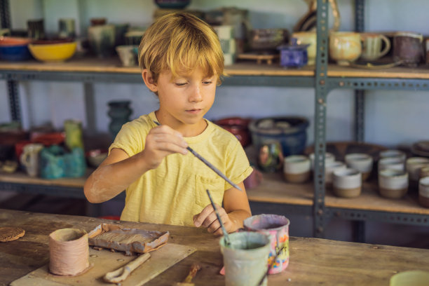 男孩在陶艺坊做陶罐图片下载