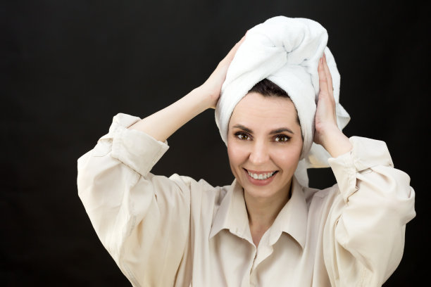 一名成年妇女，洗澡后头部有毛巾伤，黑色背景图片下载