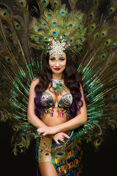 黑发女人，头上插着羽毛，映衬着华美的孔雀羽毛图片下载