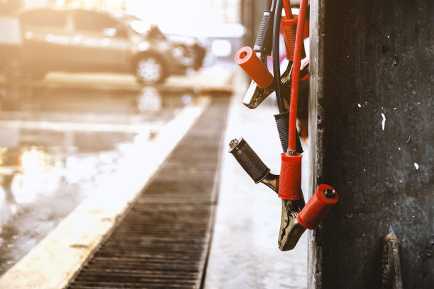 汽车维修中心的近距离电池充电器，背景有软对焦和过光图片下载