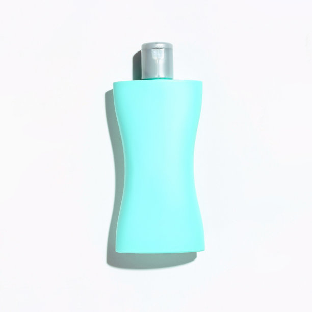 绿松石色的塑料瓶与银色的水龙头在白色的背景与阴影图片下载