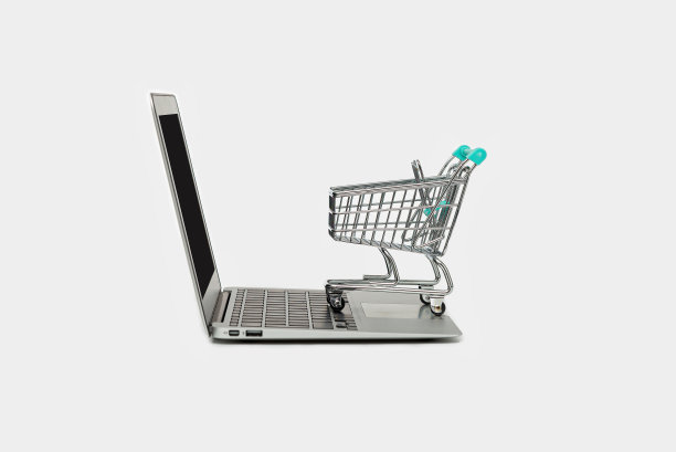 网上购物的概念与笔记本电脑和购物车隔离在白色，复制空间图片下载