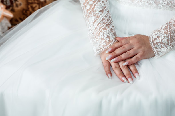 新娘的手放在白色的婚纱上图片下载