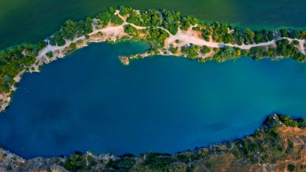 照片从一个美丽的夏季风景河的无人机。美丽的天蓝色湖泊，有陡峭的岩石岸。蓝色湖泊的鸟瞰图。图片下载